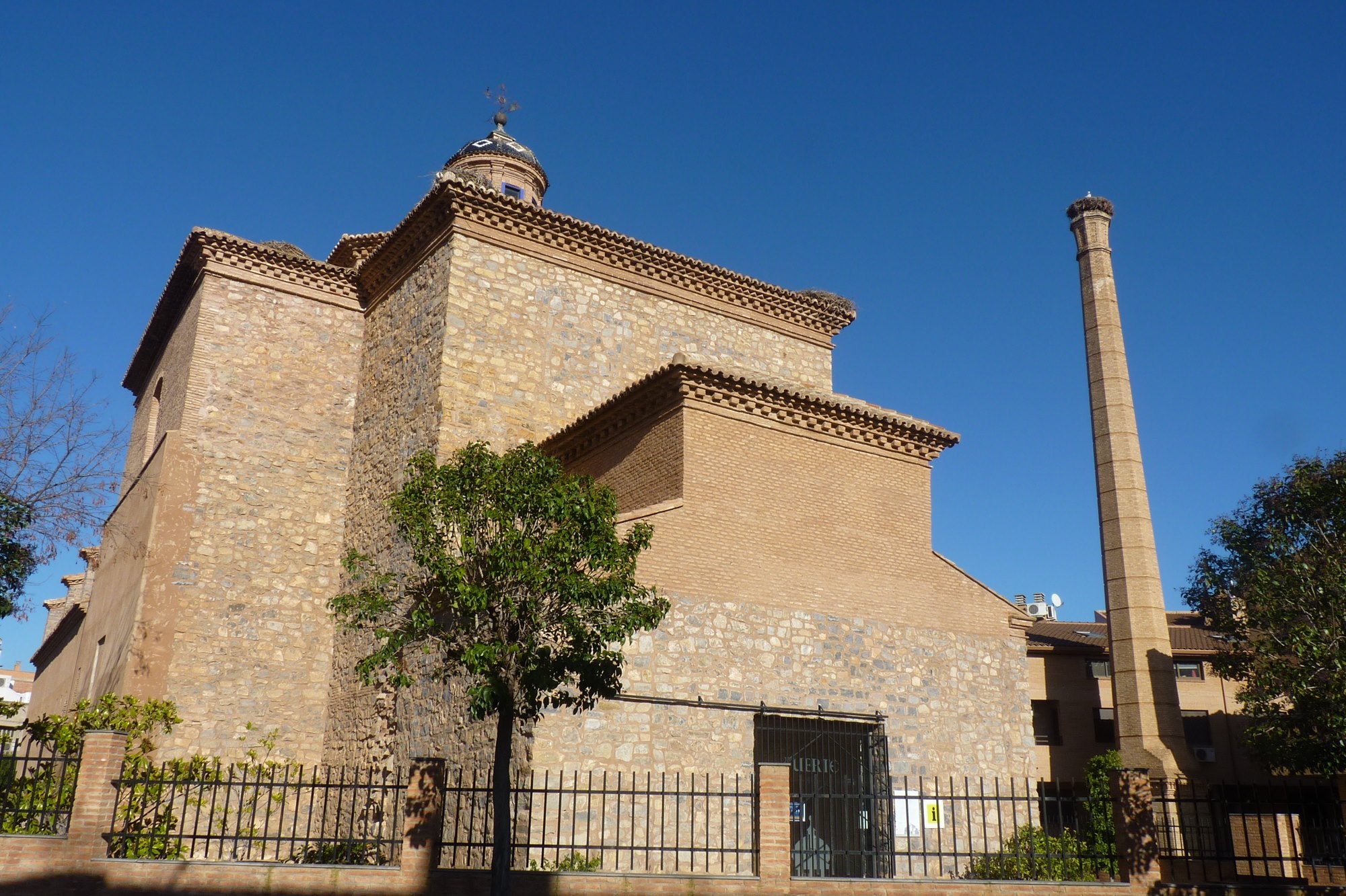 El convento de San Lorenzo se encuentra al lado de la chimenea de la antigua fábrica alcoholera.