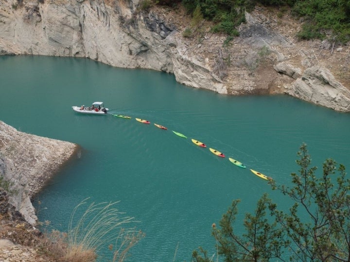 Una lancha arrastra a los kayaks vacíos por los acantilados del Congosto de Mont Rebei. Foto: Shutterstock.