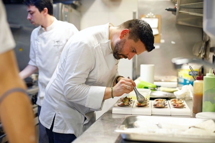 El chef Javier Izarra emplatando unas zamburiñas, en el restaurante Tamarises Izarra, en Getxo, Vizcaya.