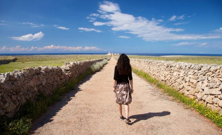 Mujer paseando por un paisaje naturista de Menorca