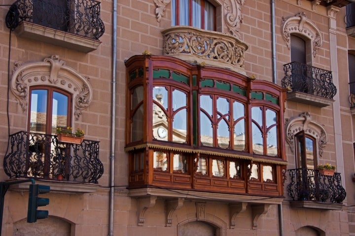 Balconada típica de la ciudad, con el reflejo del Ayuntamiento en los cristales. Fotografía: Atxu Ayerra.
