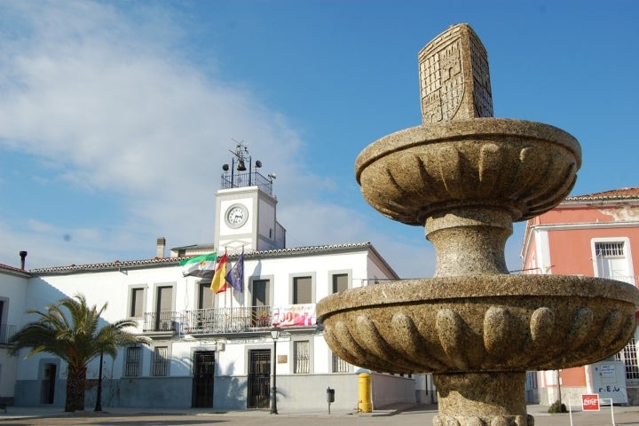 Ayuntamiento de Monroy con su fuente en primer plano. Fotografía: José Antonio Cotallo López vía Wikipedia / CC BY-SA.