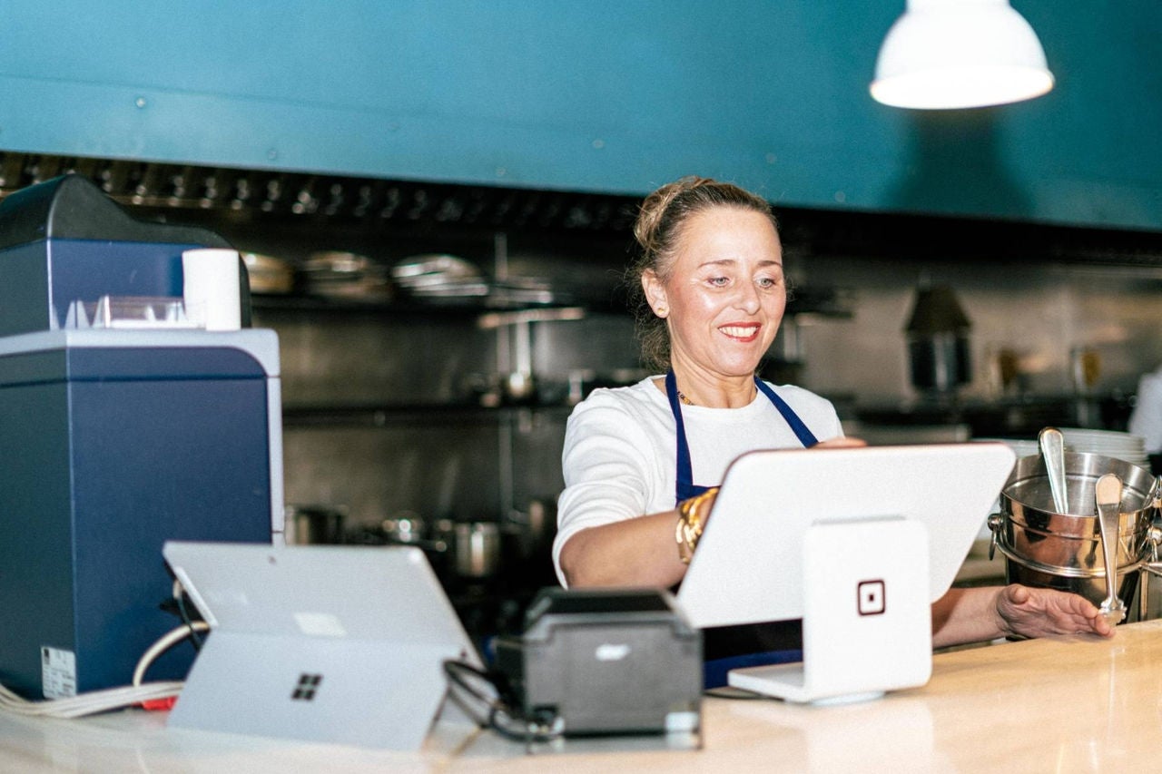 Trabajadora utilizando el comandero digital para tomar nota o cobrar a los clientes